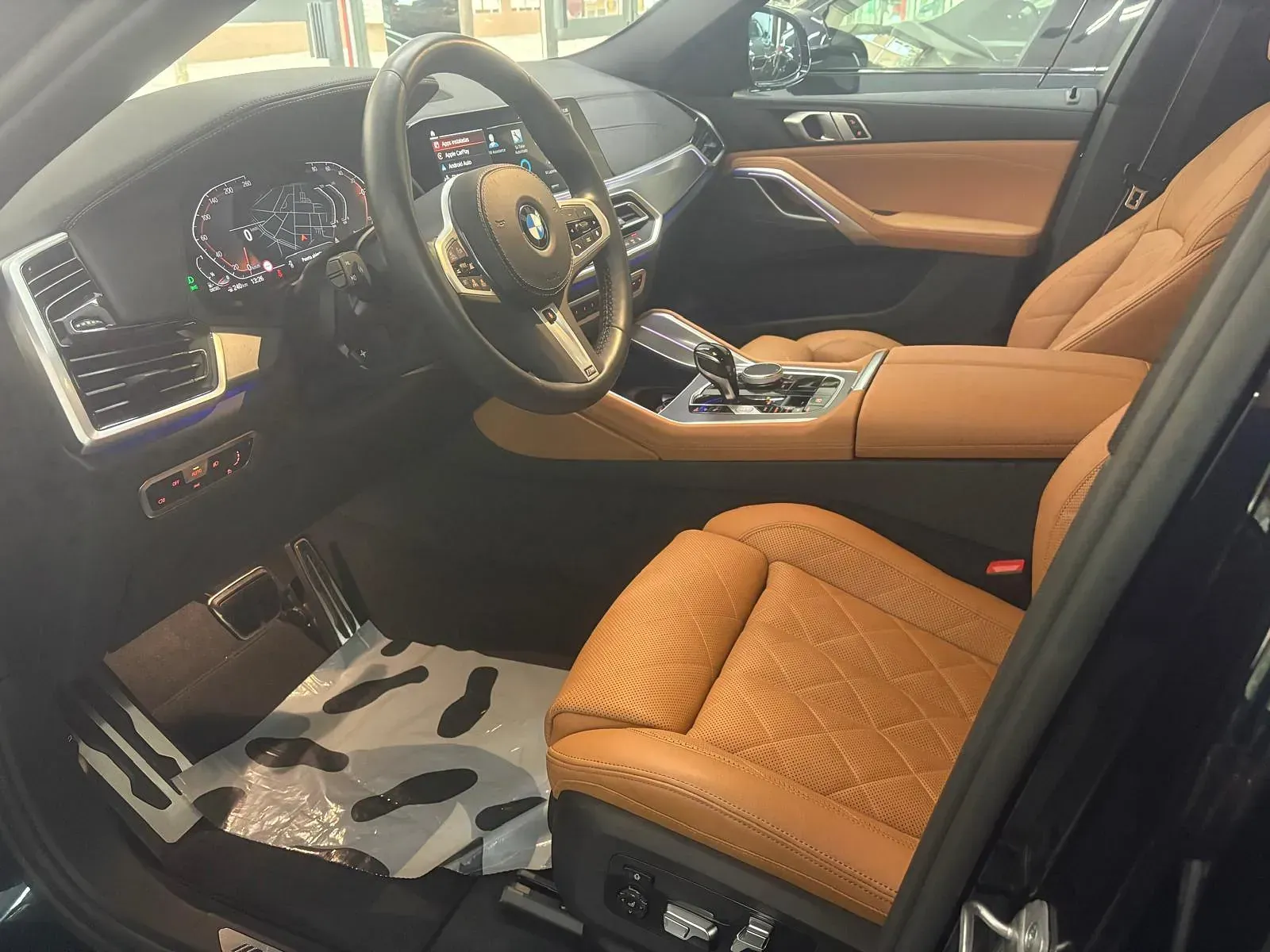 El interior de un coche con asientos marrones y un volante.