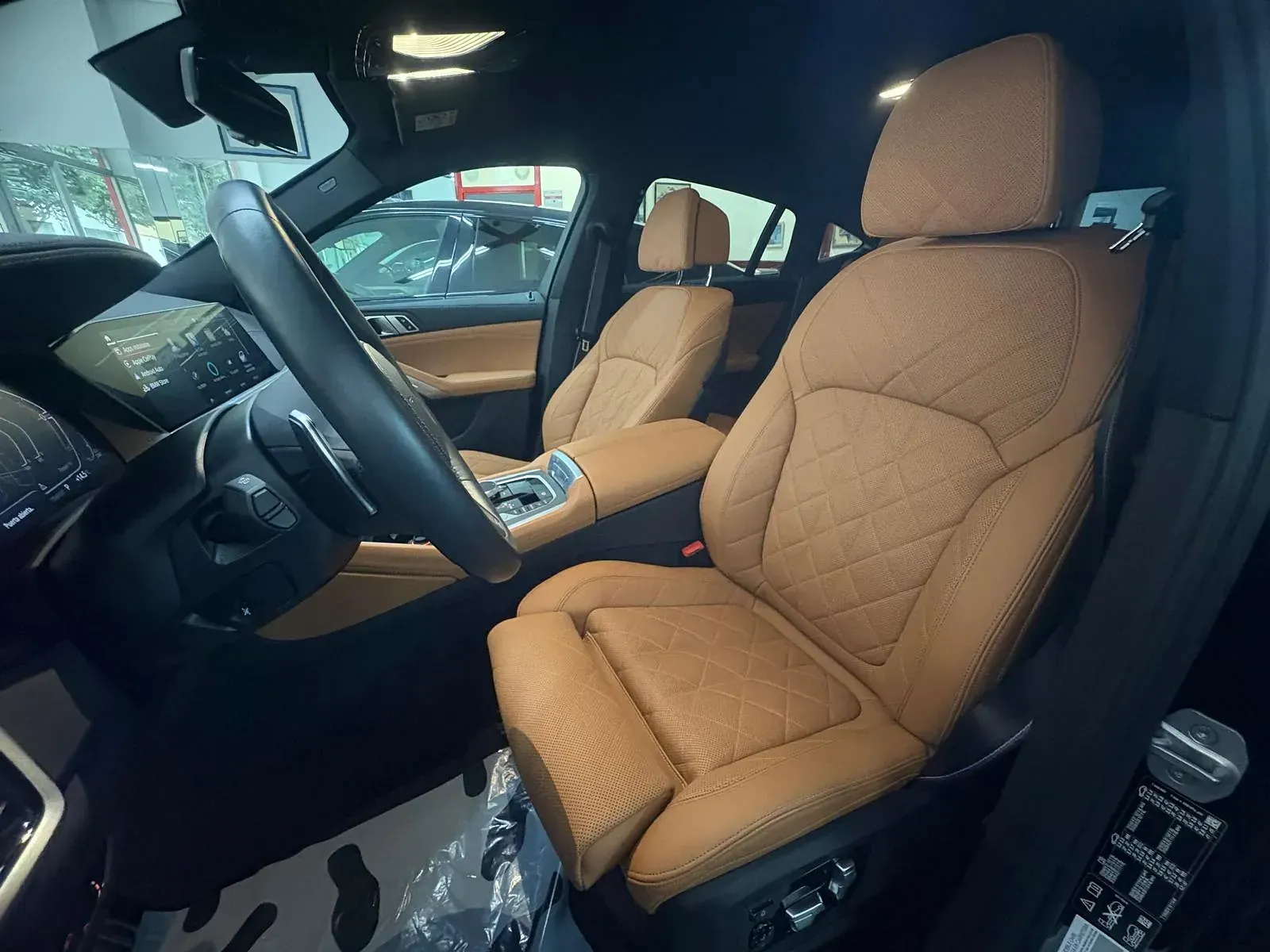 El interior de un coche con asientos de cuero marrón y un volante.