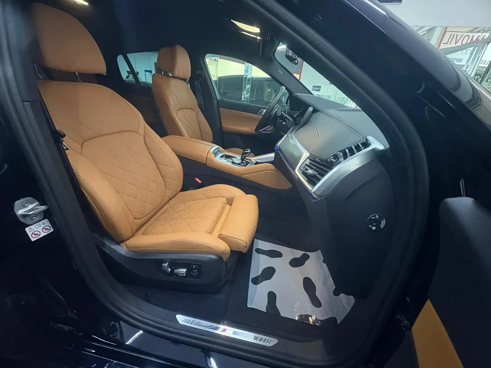 El interior de un coche negro con asientos marrones.