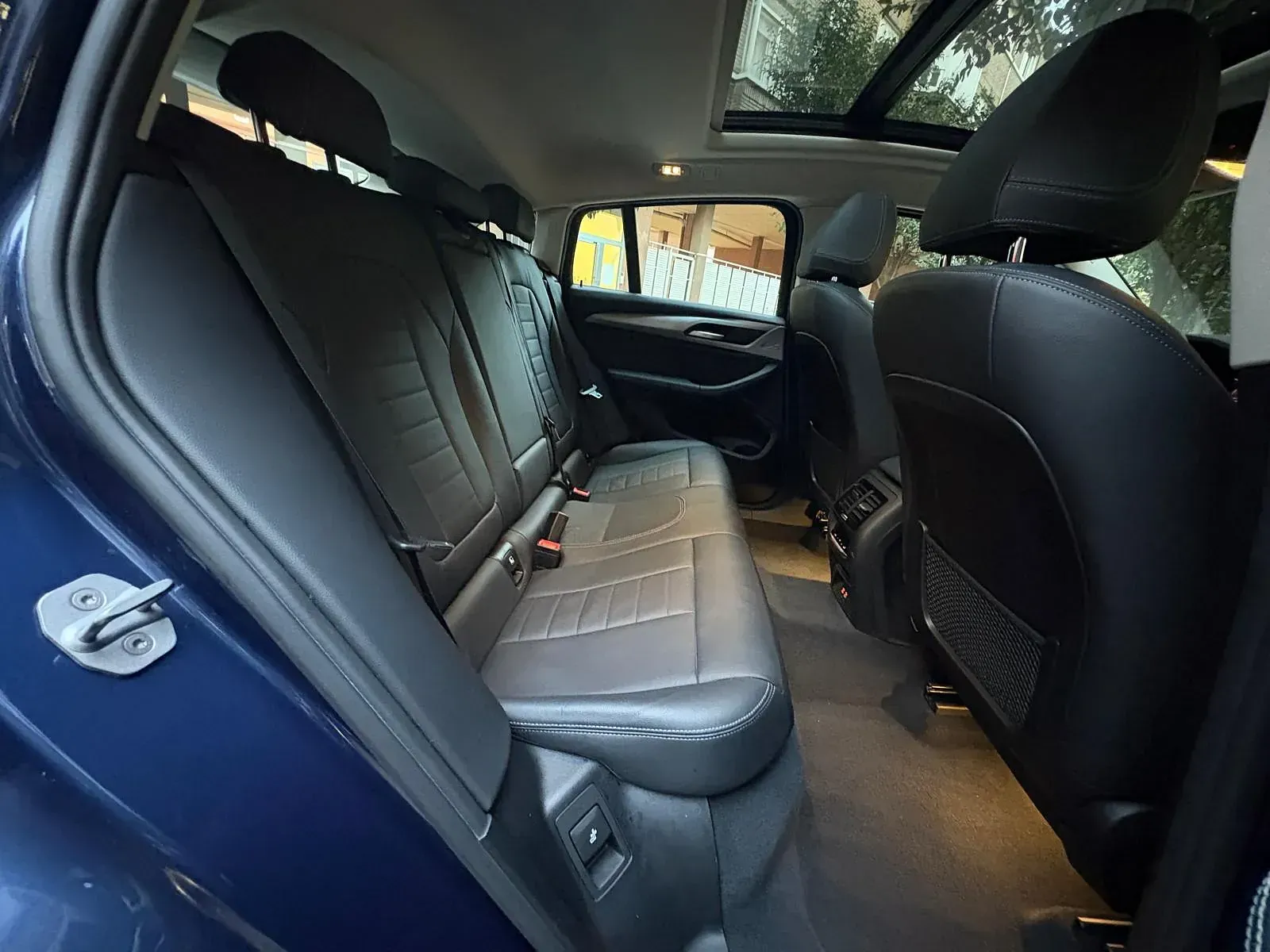 El asiento trasero de un coche azul con techo corredizo