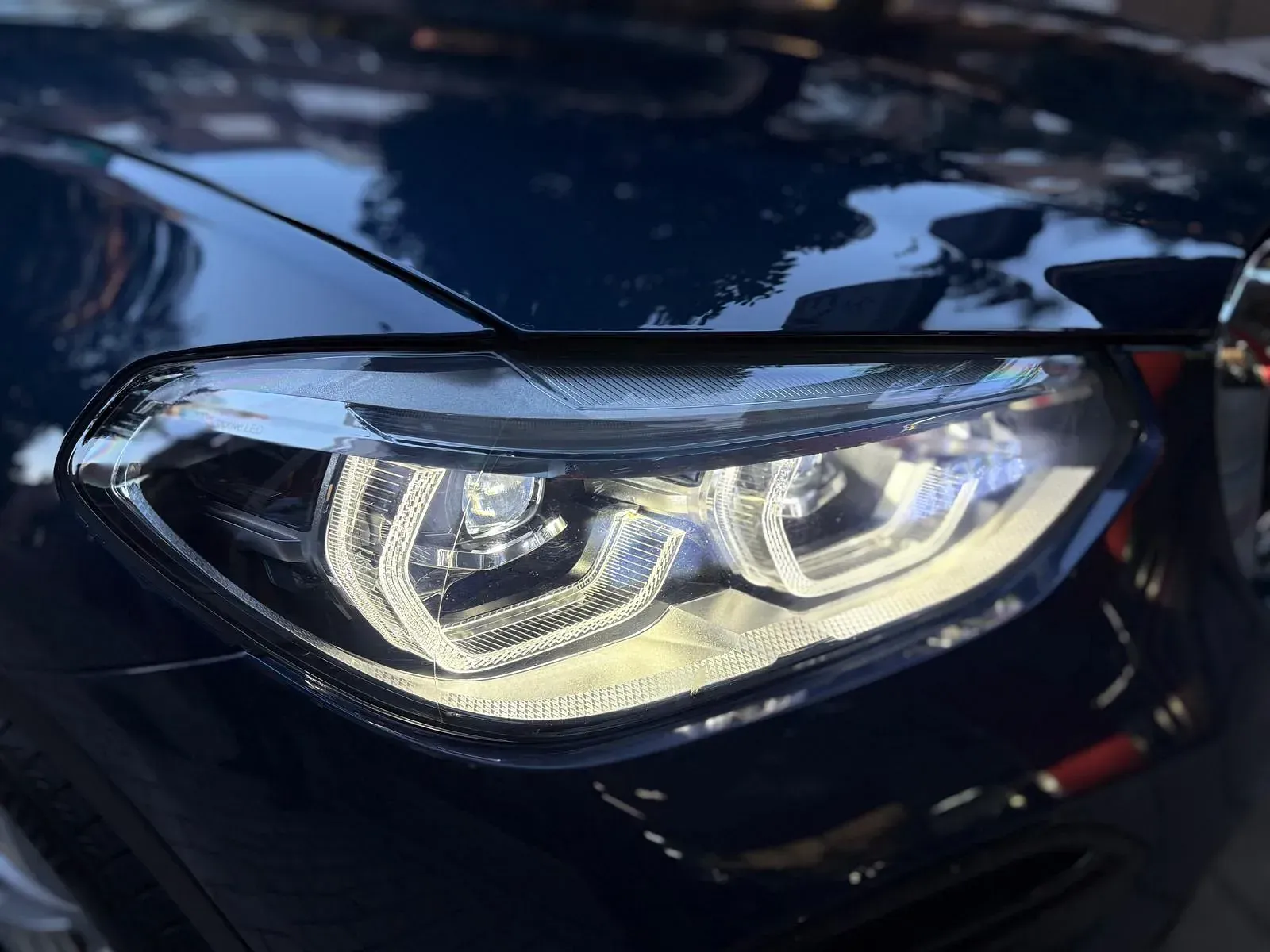 Un primer plano del faro de un coche negro.