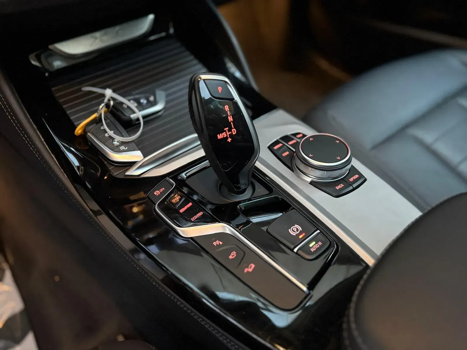 Un primer plano de la palanca de cambios de un coche con una llave puesta.