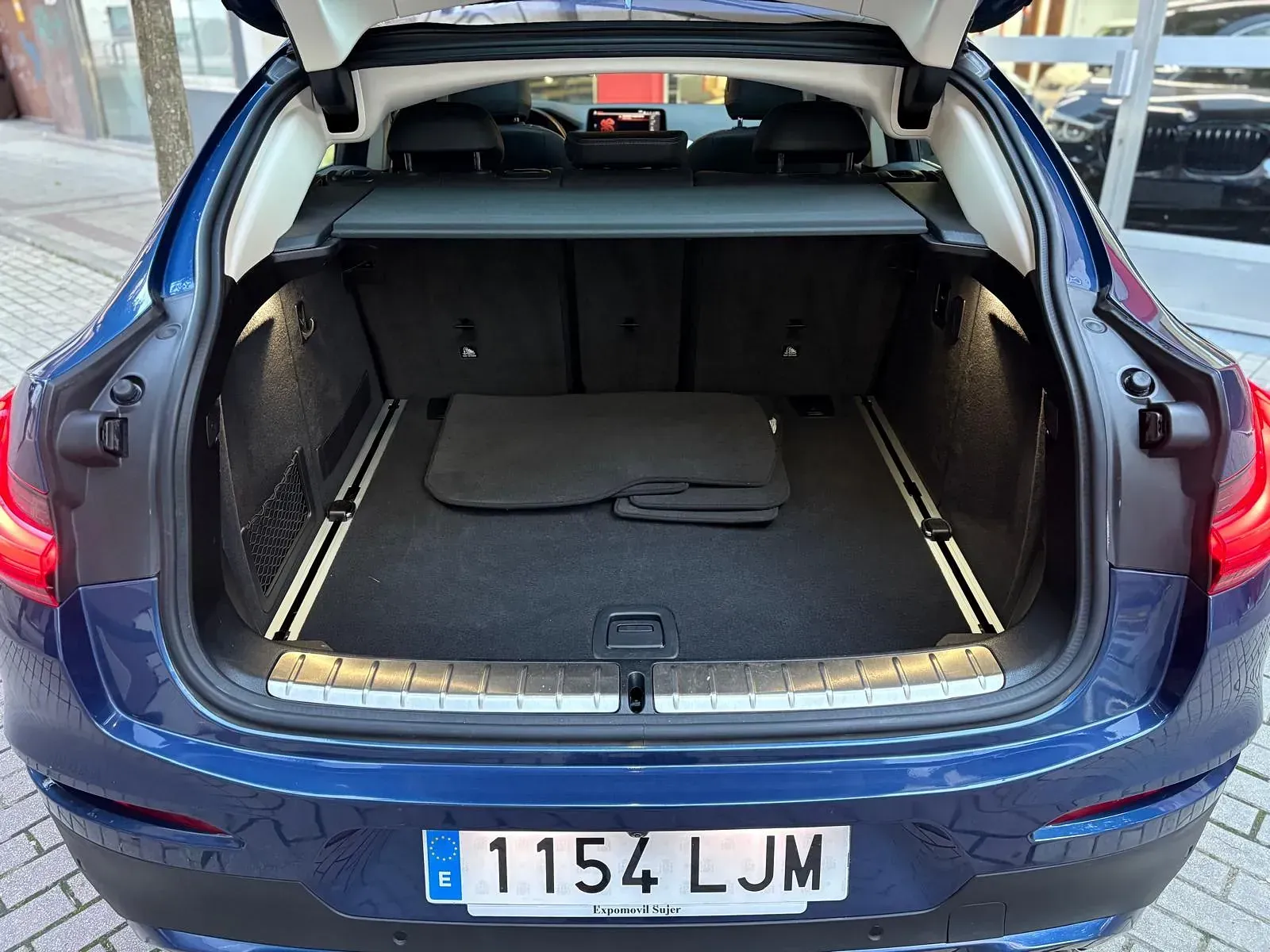 El maletero de un coche azul con matrícula que dice 1154 ljm