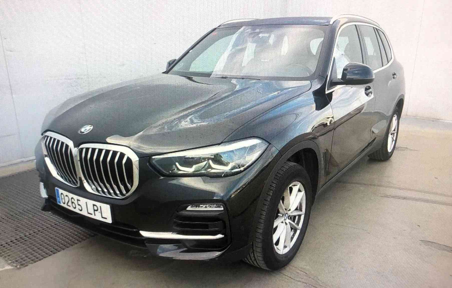 Un BMW X5 negro está estacionado frente a un edificio.