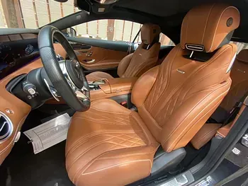 El interior de un Mercedes Benz Clase S Coupé con asientos de cuero marrón y volante.