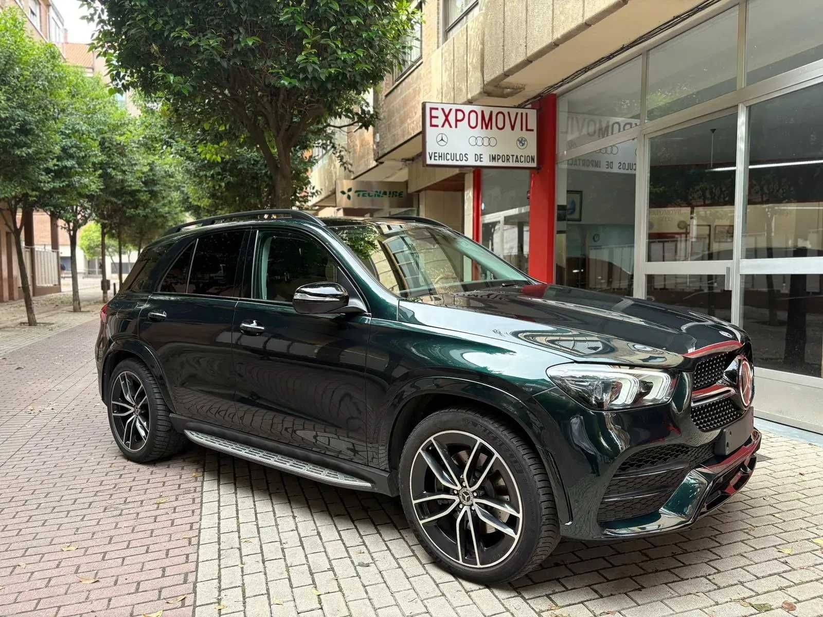 Una camioneta negra está estacionada en una acera de ladrillos frente a un edificio.