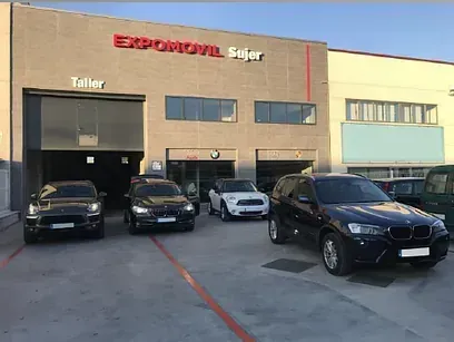Un grupo de coches están aparcados delante de un edificio.