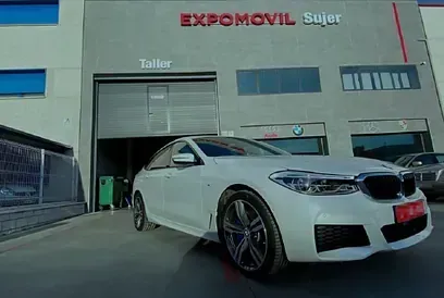 Un coche blanco está aparcado delante de un edificio.