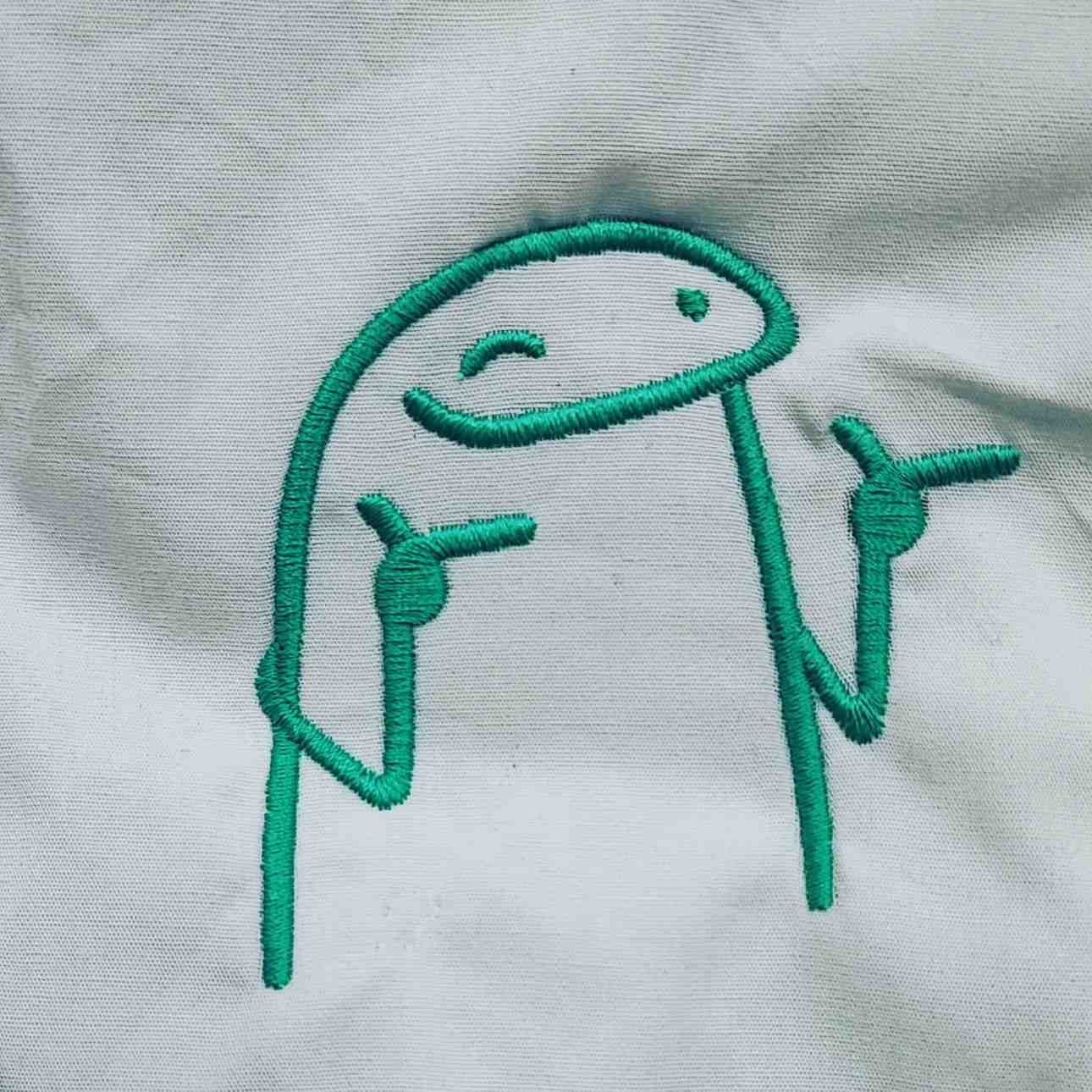 Bordado lineal en color verde azulado de un personaje