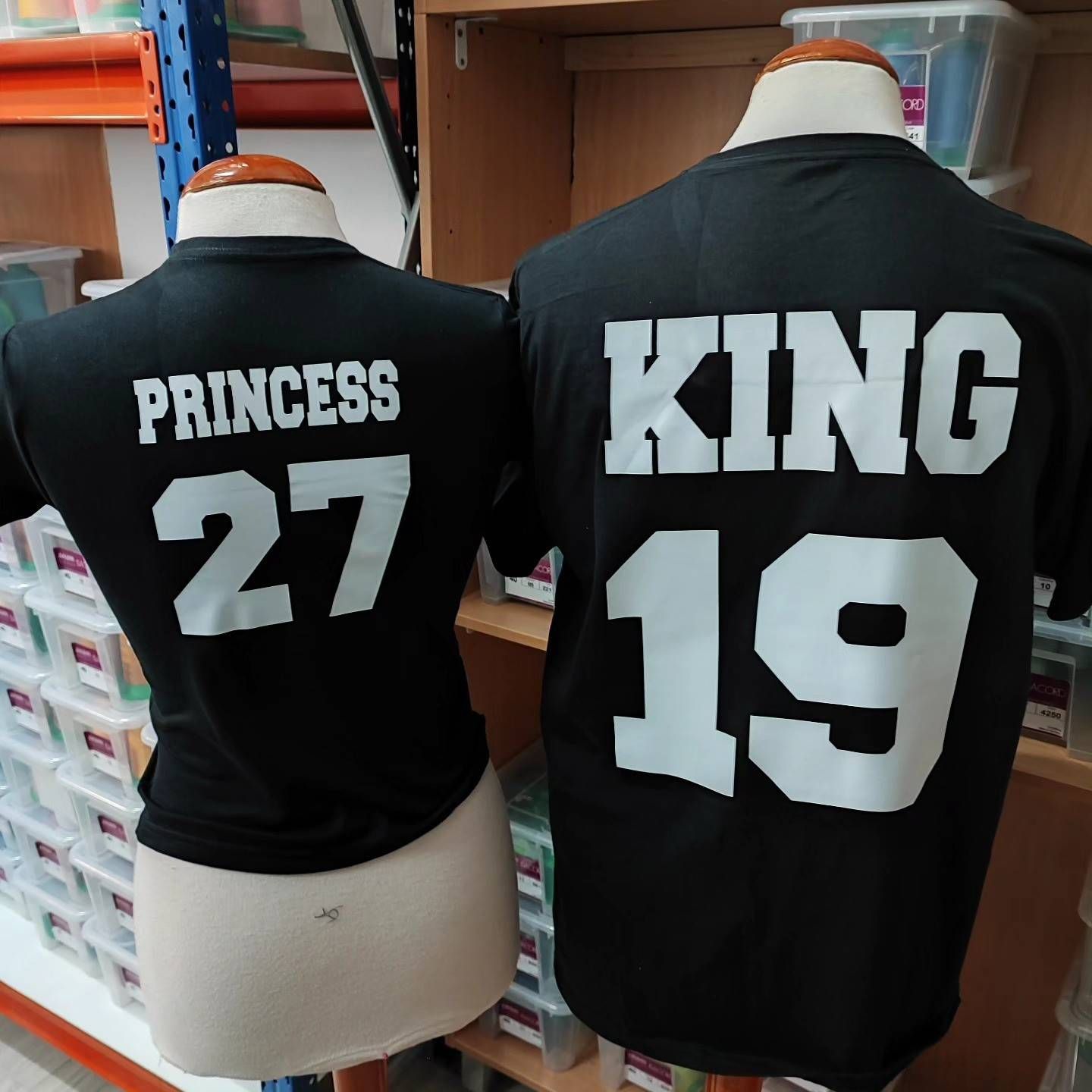 Dos camisetas negras en maniquíes, una con la etiqueta