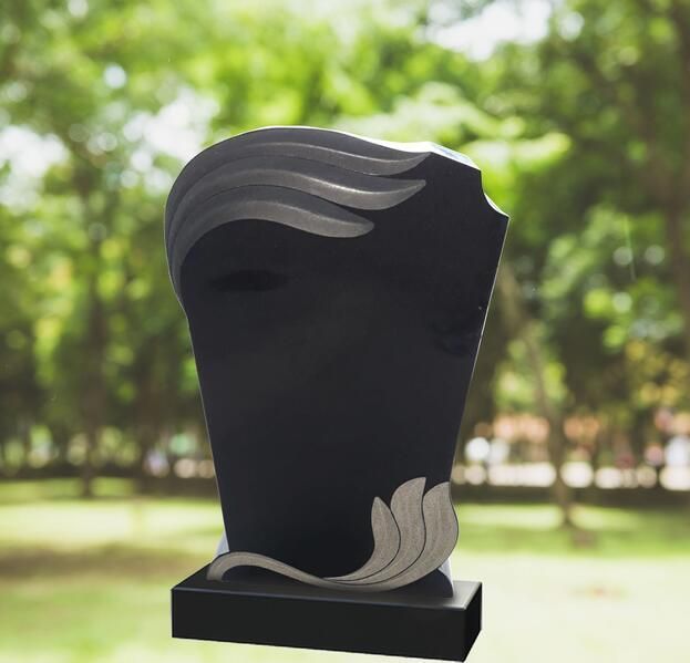 Schwarze abstrakte Skulptur mit silbernen Wellenakzenten auf einem Sockel im Freien vor verschwommenem grünem Hintergrund