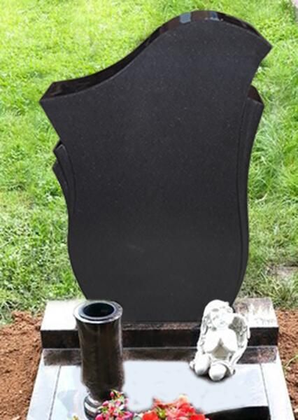 Schwarzer, aufrechter Grabstein mit kleinem Blumenhalter und weißem Ornament auf einem Sockel in einer Friedhofsumgebung