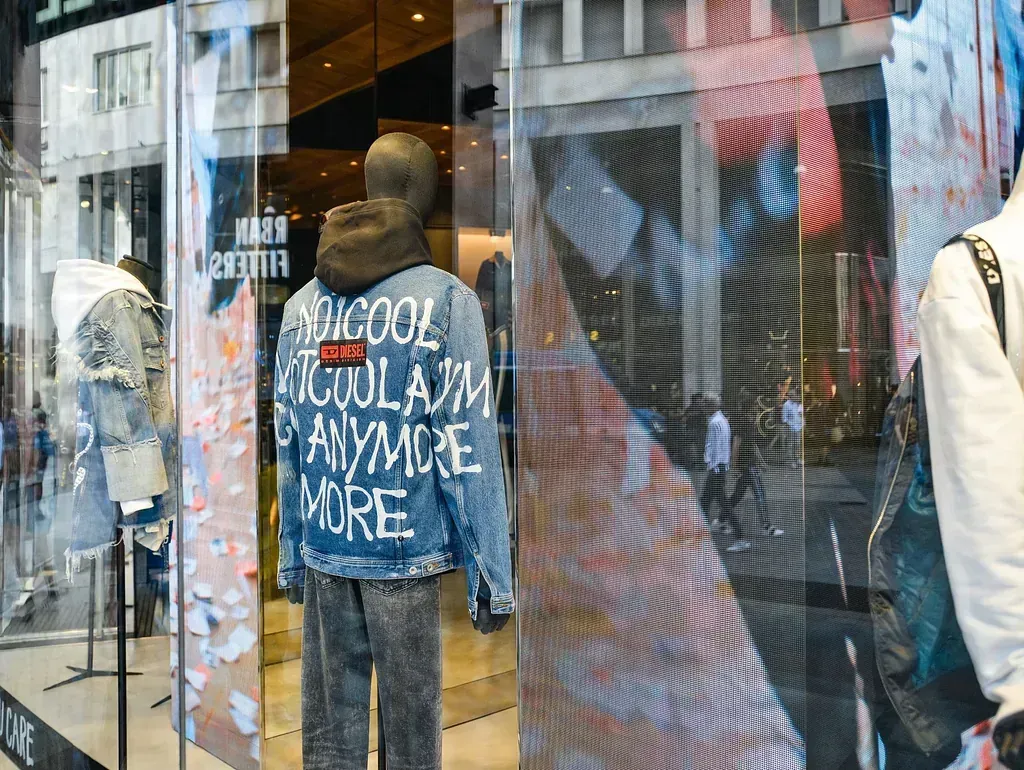 Un maniquí que lleva una chaqueta vaquera con un grafiti está en el escaparate de una tienda.
