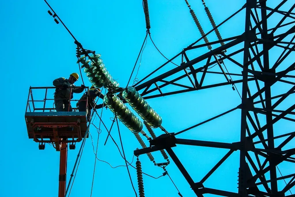 Un hombre en un cubo está trabajando en una línea eléctrica.