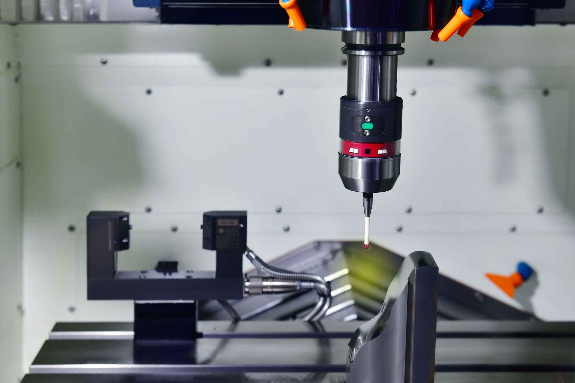 Máquina CNC con sonda inspeccionando una pieza metálica.