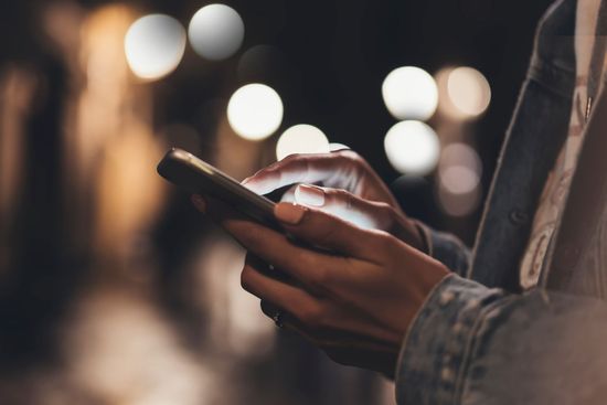 Una persona sostiene un teléfono celular en sus manos.