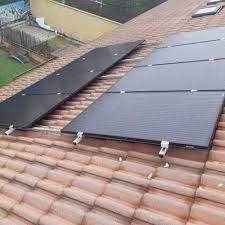 Una fila de paneles solares colocados encima de un techo de tejas.
