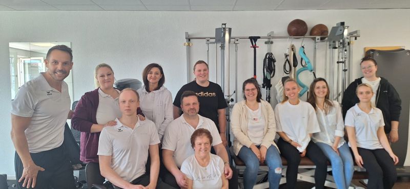 Eine Gruppe von Menschen posiert in einem Fitnessstudio für ein Foto.