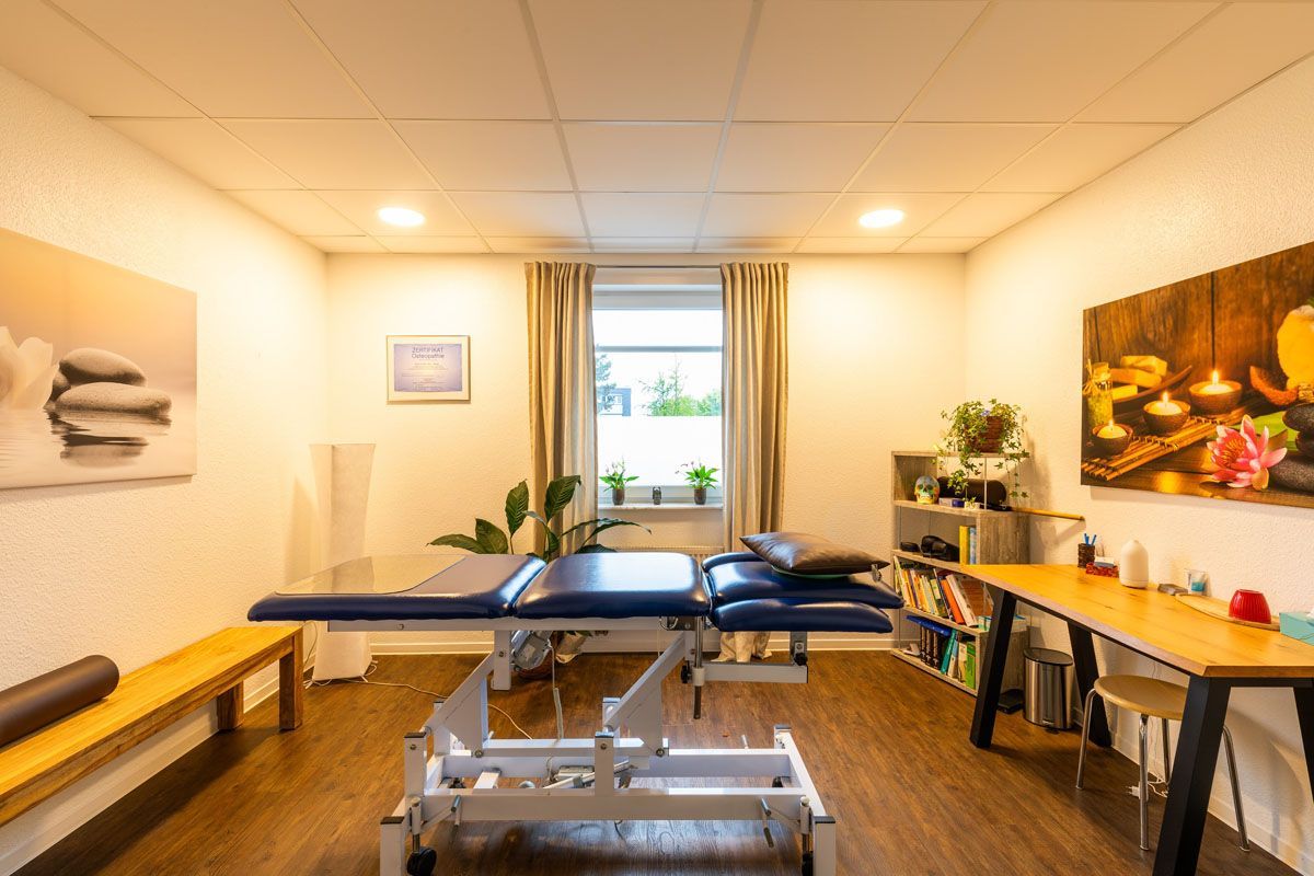 In der Mitte des Raumes steht eine Massageliege.