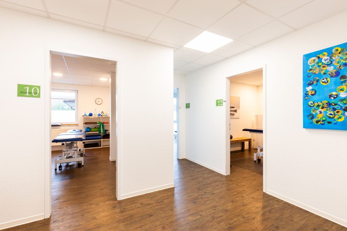 Ein Flur in einem Krankenhaus mit einem Tisch und einem Gemälde an der Wand.