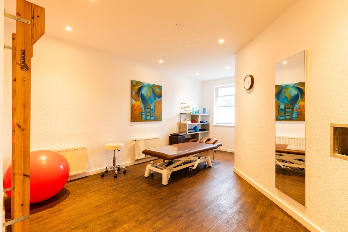 In der mitte des raumes steht eine massageliege.