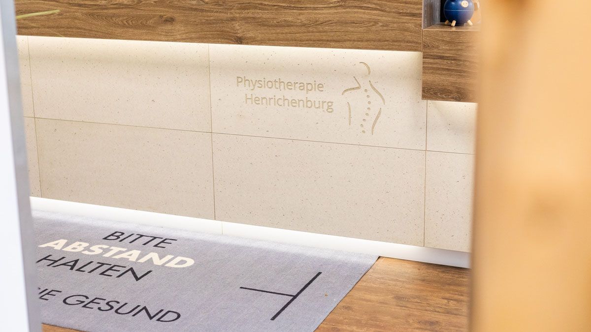 Vor einem Rezeptionstresen liegt eine Fußmatte mit der Aufschrift „Rote Abstand halten“.