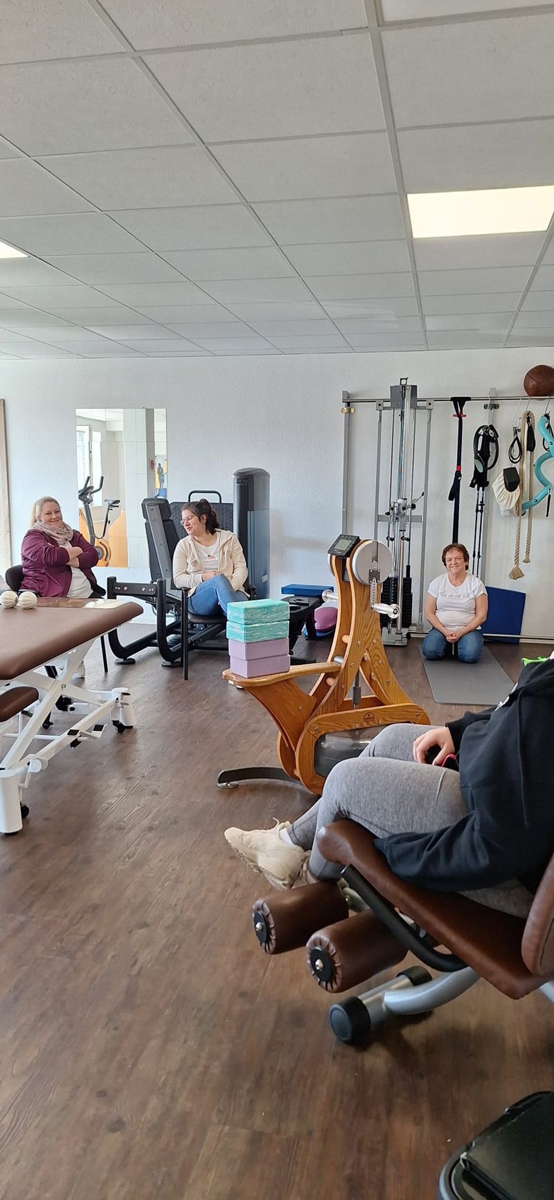 Eine Gruppe von Menschen sitzt in einer Turnhalle.