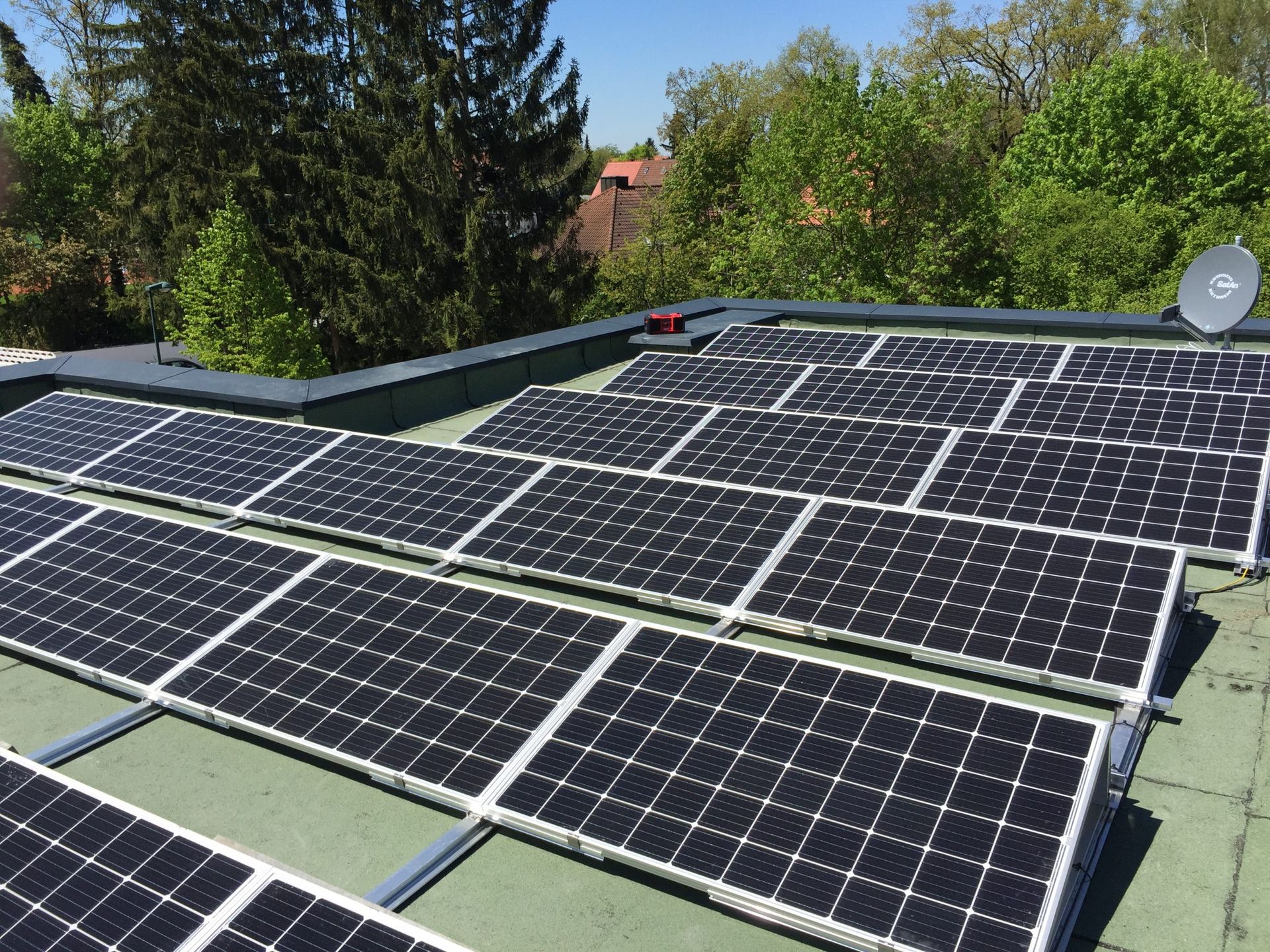 eine Reihe von Sonnenkollektoren auf dem Dach eines Hauses