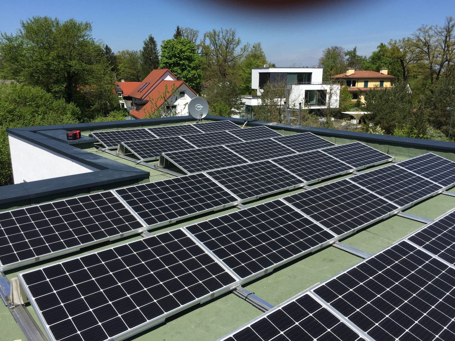 eine Reihe von Sonnenkollektoren auf dem Dach eines Hauses