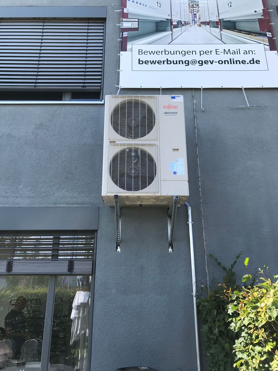 es weißes Fujitsu-Kühlgerät an einer grauen Wand