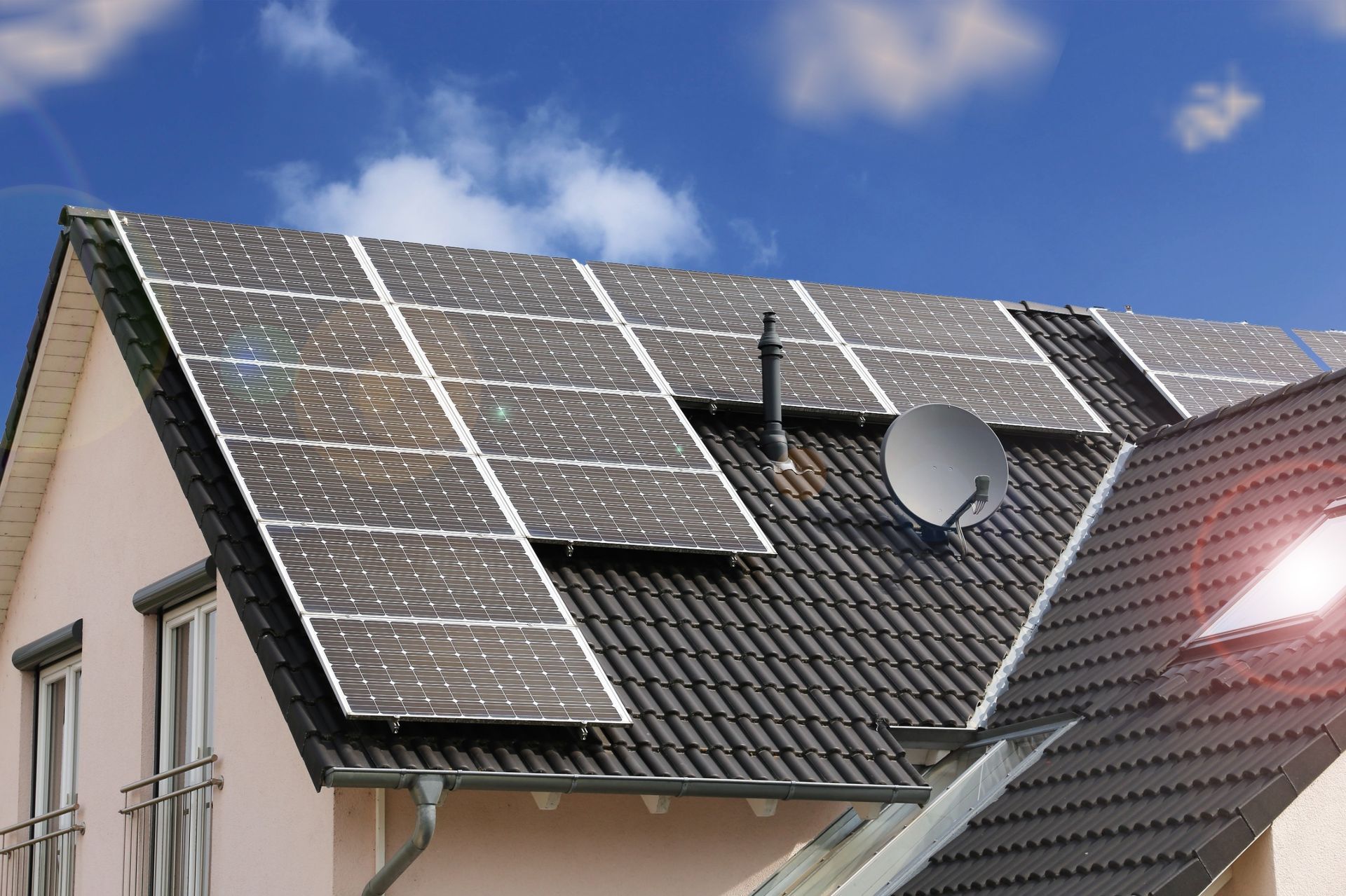 Una casa con paneles solares y una antena parabólica en el tejado.