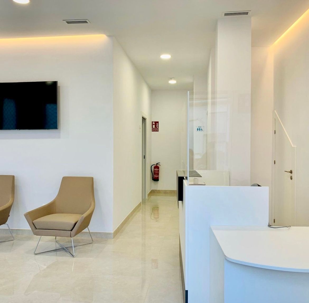 Moderno pasillo de oficina con mostrador de recepción, zona de espera y equipo de seguridad contra incendios.