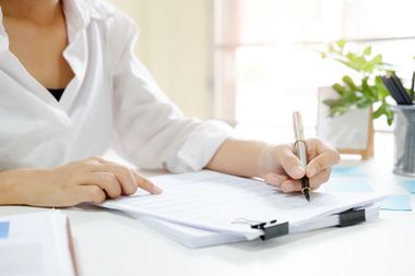 Une femme signe des documents