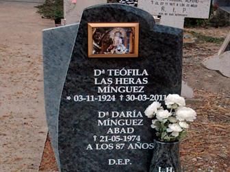 Lápida con inscripciones y foto enmarcada. Nombres, fechas y la inscripción 