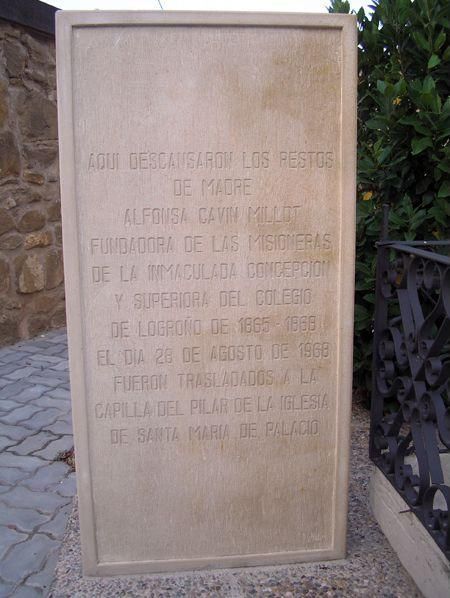 Monumento de piedra con texto grabado en español; exterior.