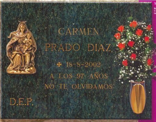 Lápida con estatua dorada de María y el niño, nombre 