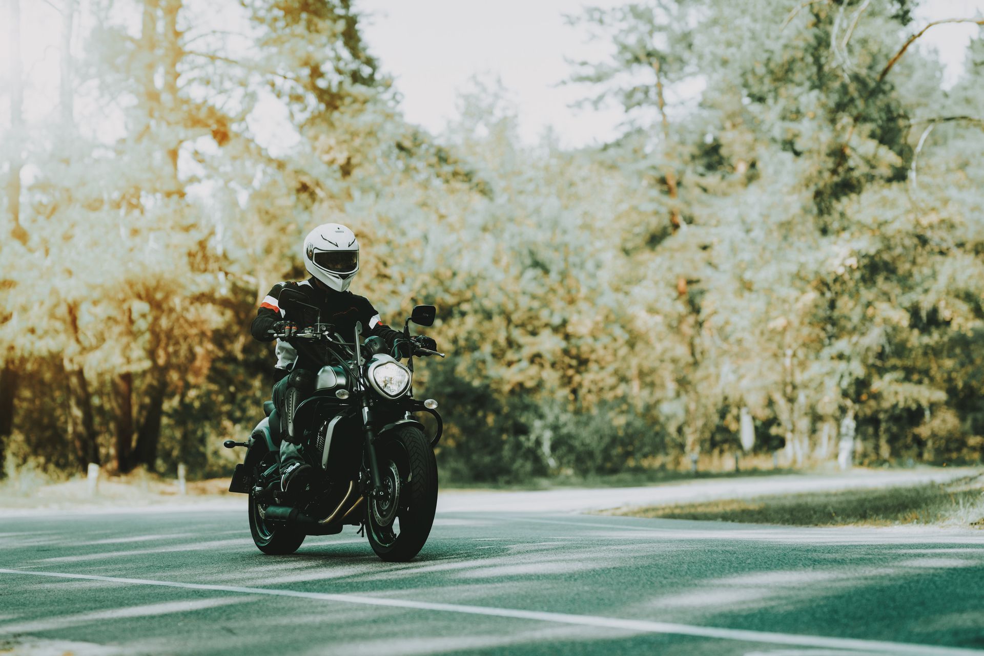 Un hombre va conduciendo una motocicleta por una carretera.