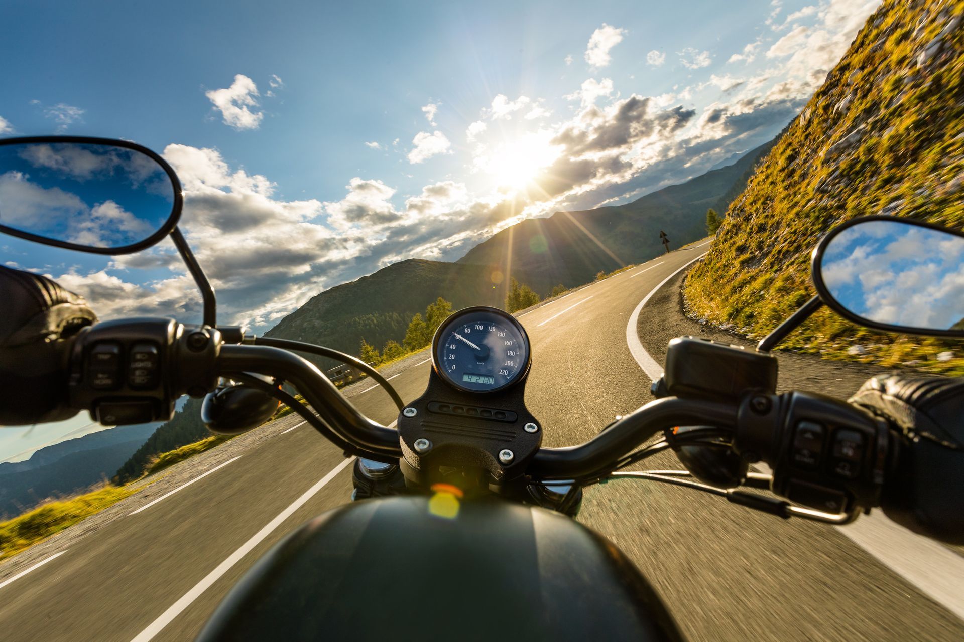 Una persona va conduciendo una motocicleta por una carretera de montaña.