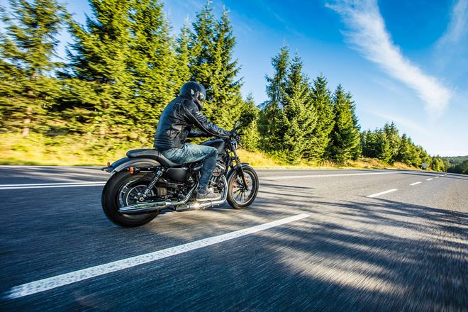 Un hombre va conduciendo una motocicleta por una carretera.
