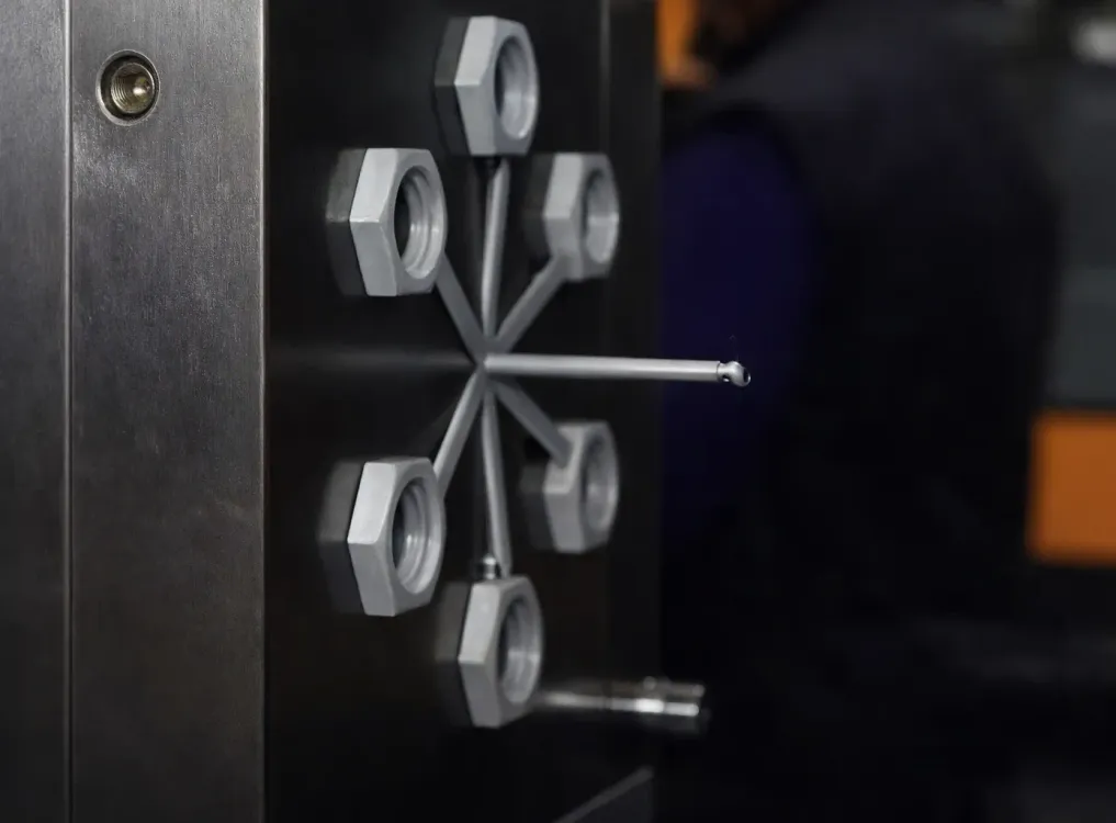 Una pieza mecánica que presenta un patrón en forma de estrella de seis tuercas grises conectadas