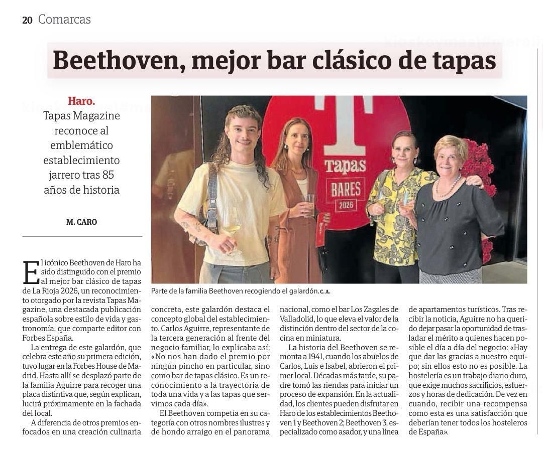 Grupo posando ante un fondo rojo en un artículo titulado “Beethoven, mejor bar clásico de tapas”