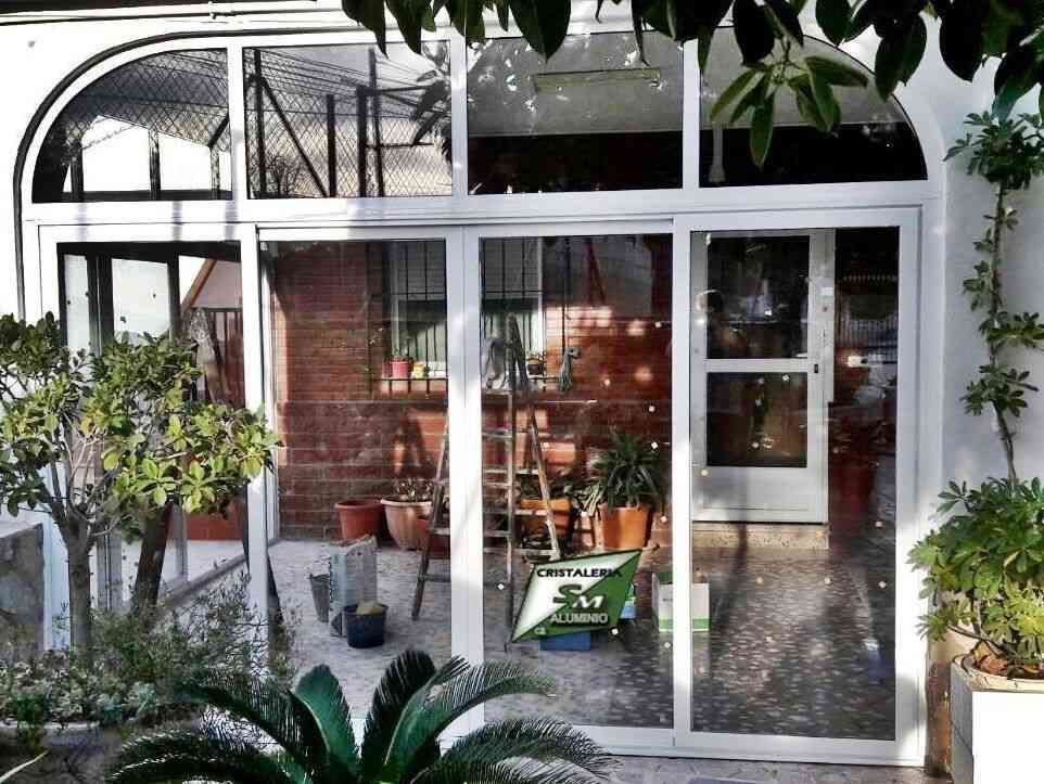 Una casa con muchas ventanas y plantas