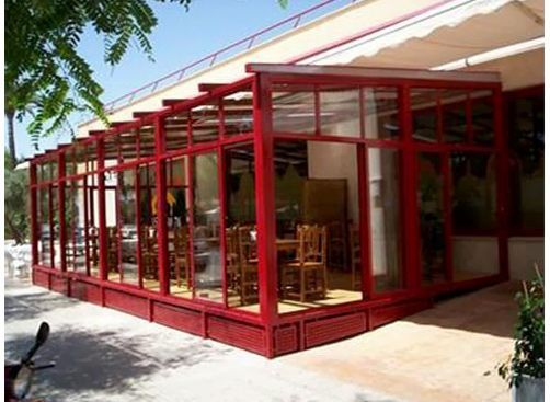 Un gran edificio rojo con muchas ventanas y sillas.