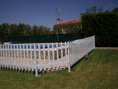 Una valla blanca rodea una piscina