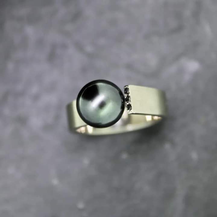 Goldschmiede Norys - Nahaufnahme eines Ringes, Goldschmied beim Einsetzen von Schmucksteinen