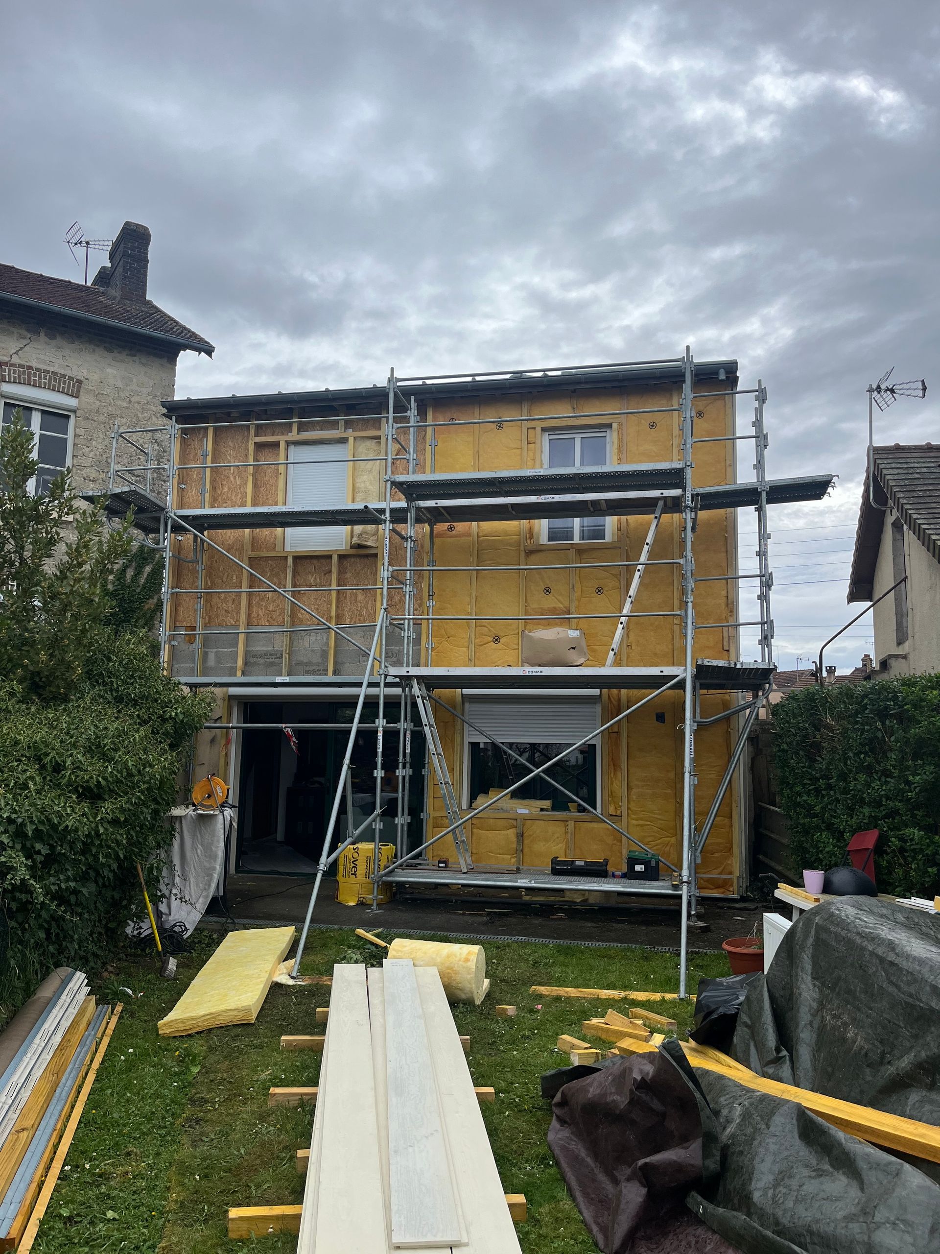 Échafaudage devant une petite maison côté jardin