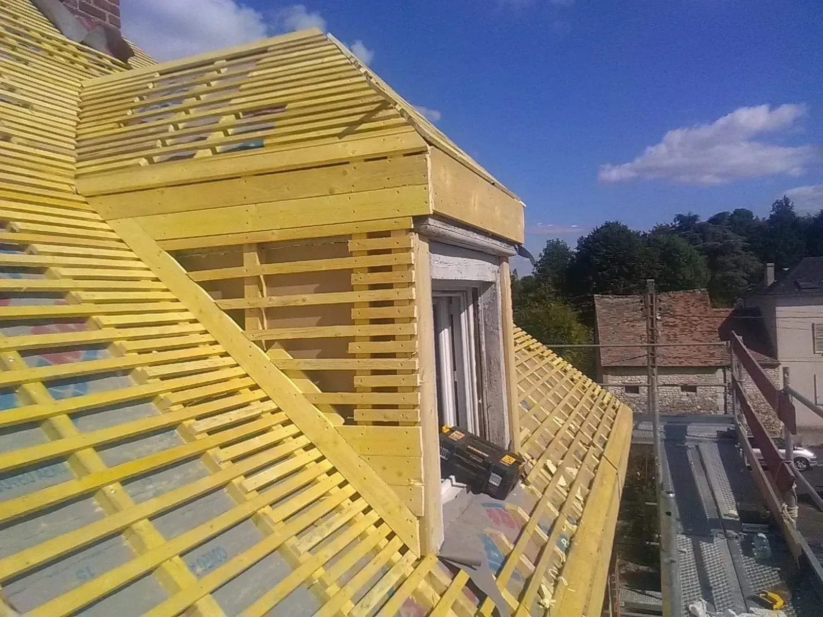 Multiples tiges de bois clair recouvrant une toiture en rénovation 02