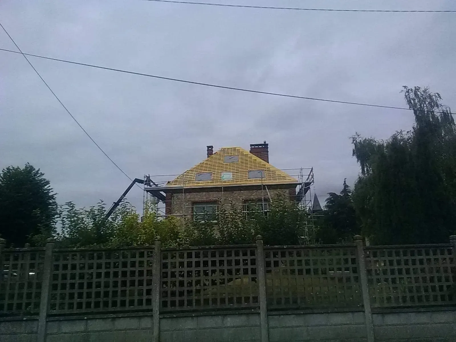 Multiples tiges de bois clair recouvrant une toiture en rénovation 04