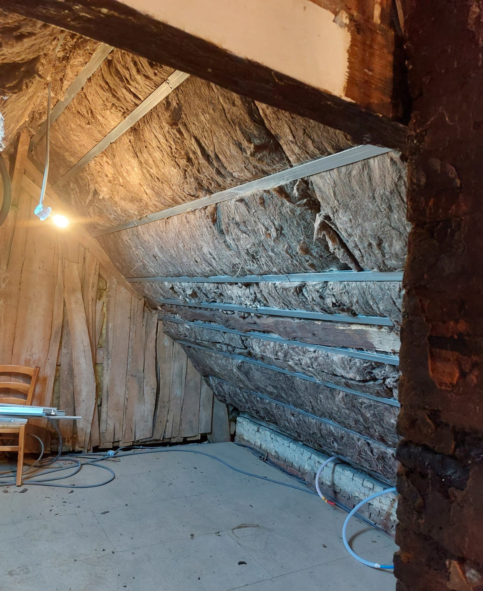 Isolant sous la toiture maintenue par des bandes de métal