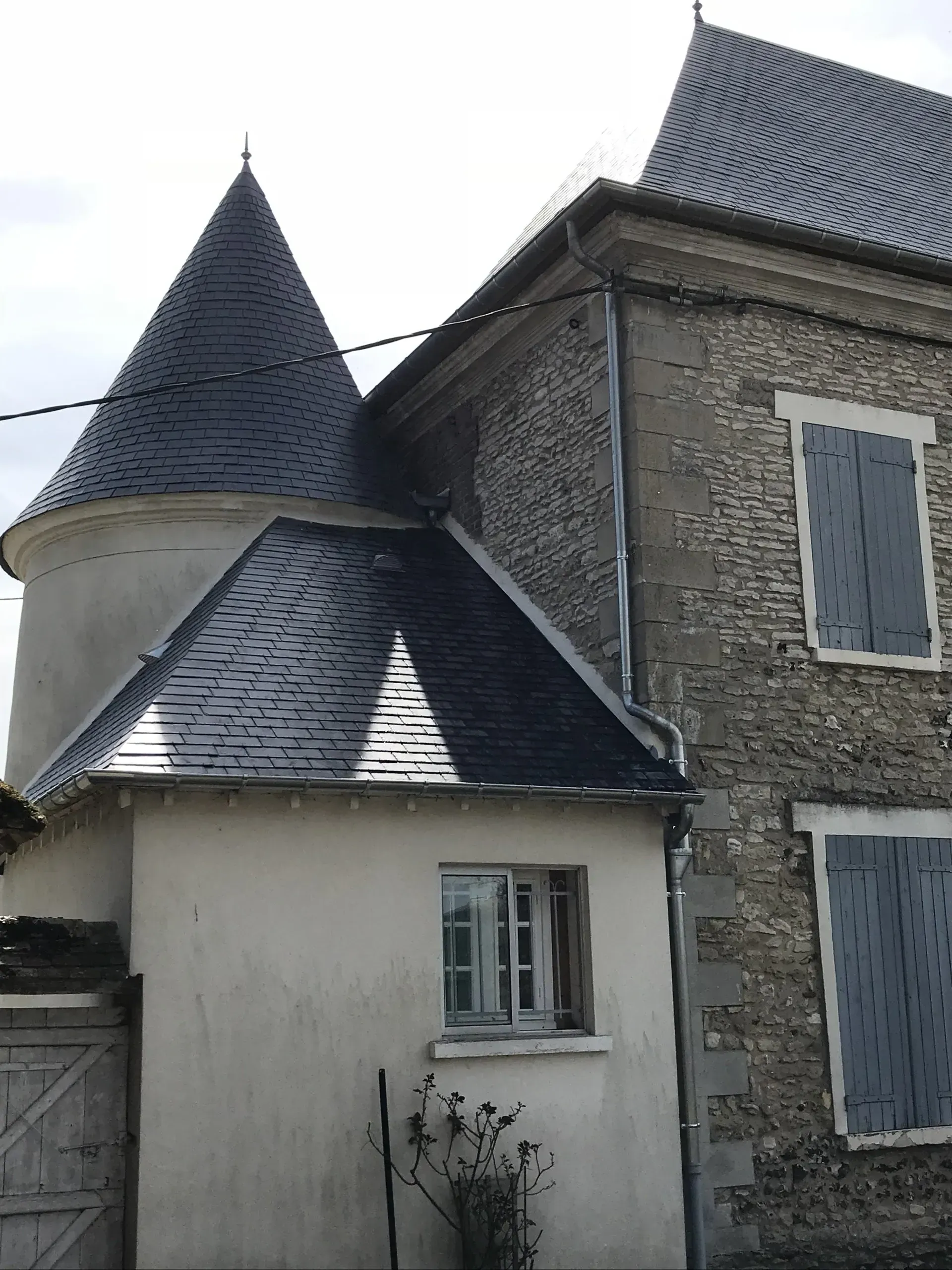 Partie d'une maison dont une sorte de tour a un toit en forme de cône